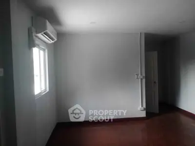 Spacious empty room with air conditioning and window, ready for customization.