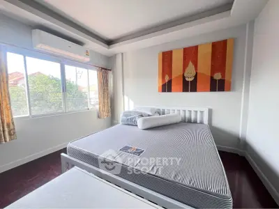 Bright bedroom with large window and modern decor