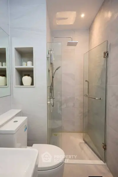 Modern bathroom with glass shower and sleek fixtures in a contemporary home.
