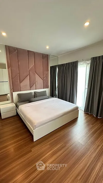 Spacious modern bedroom with elegant wood flooring and stylish decor
