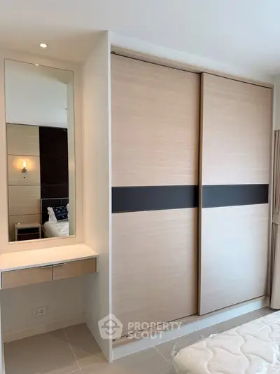 Modern bedroom with sleek sliding wardrobe and stylish vanity mirror