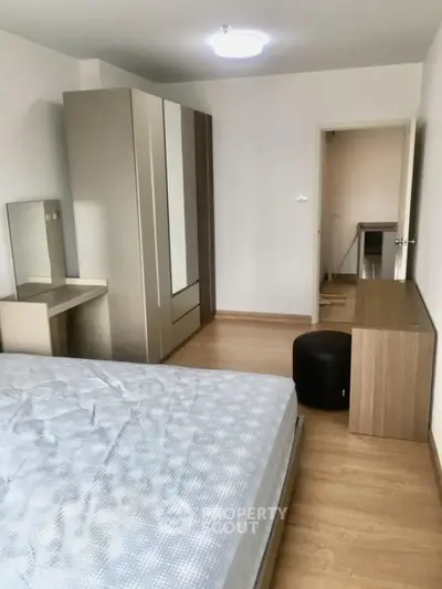 Modern bedroom with sleek furniture and ample storage space