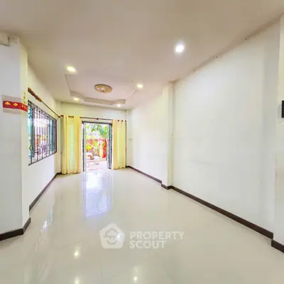 Spacious empty living room with bright lighting and open view to garden
