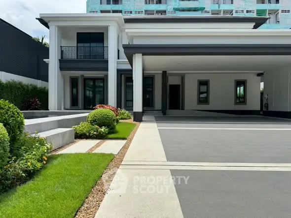 Luxurious modern house exterior with spacious driveway and manicured garden.