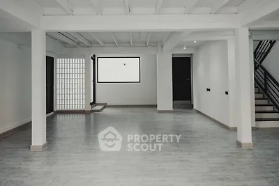 Expansive and versatile living space with polished floors, high ceilings, and a modern staircase, perfect for personalizing your dream home.