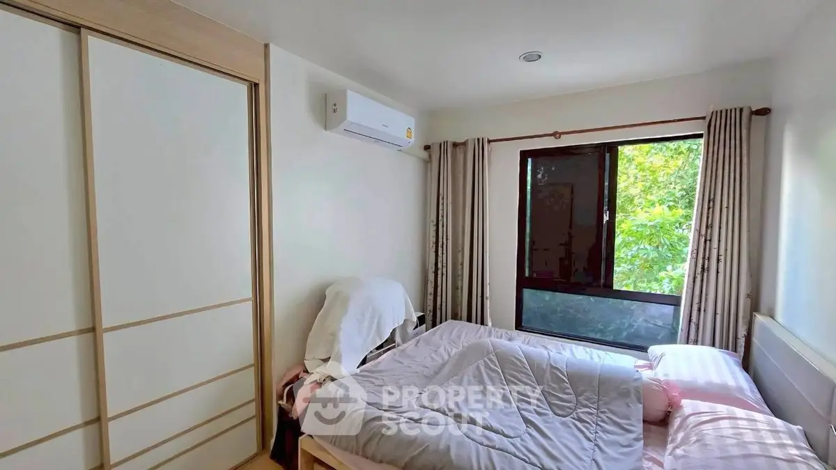 Cozy bedroom with large window and air conditioning unit