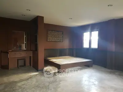 Spacious bedroom with wooden bed frame and natural light