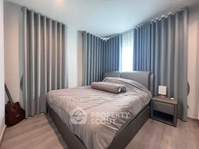 Cozy bedroom with modern decor and natural light, featuring a comfortable bed and stylish curtains.