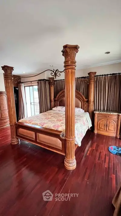 Luxurious bedroom with elegant four-poster bed and rich wooden flooring