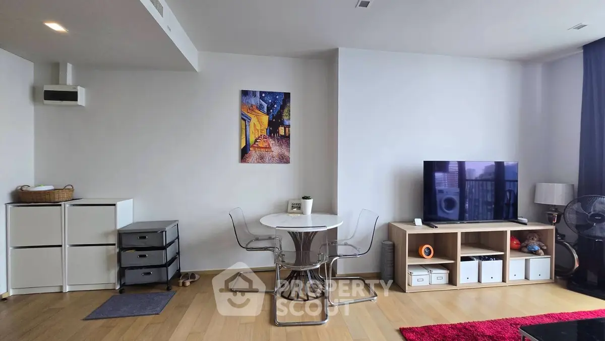 Modern living room with stylish furniture and decor, featuring a TV and dining area.