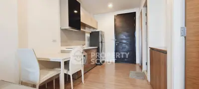 Modern kitchen with sleek design and dining area in a contemporary apartment.