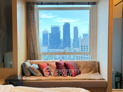 Luxurious bedroom with stunning city view and cozy seating area, perfect for urban living.