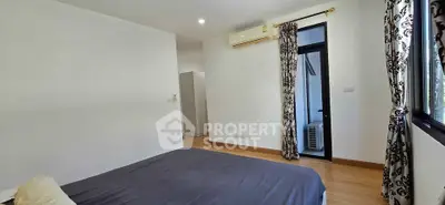 Spacious bedroom with modern decor and natural light in a stylish apartment.
