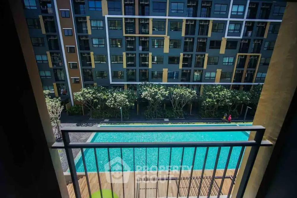 Modern apartment view with pool and lush greenery from balcony