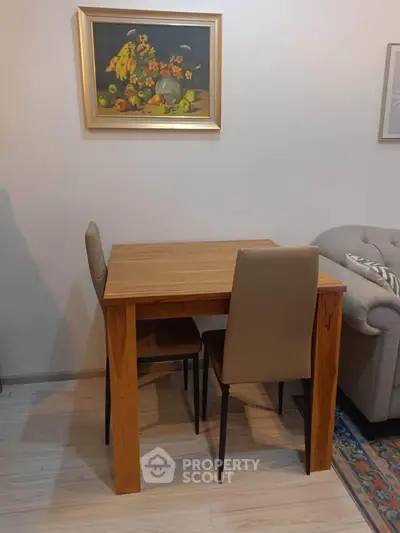 Cozy dining area with wooden table and chairs, perfect for intimate meals in a stylish living space.
