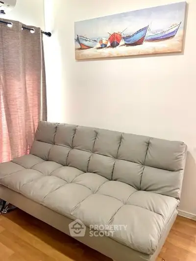 Cozy living room with stylish gray sofa and nautical wall art, perfect for relaxation.