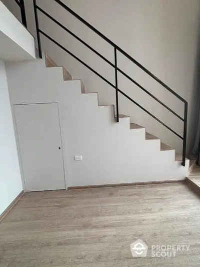 Sleek modern staircase with minimalist design, featuring clean lines and a crisp white finish complemented by a stylish black handrail.