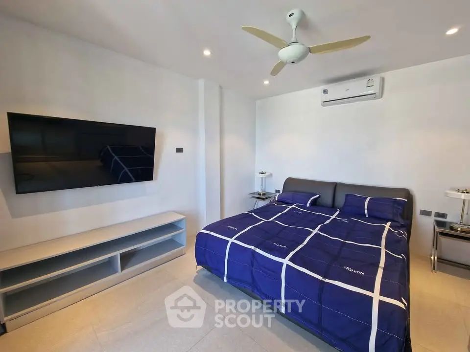 Modern bedroom with stylish decor and wall-mounted TV