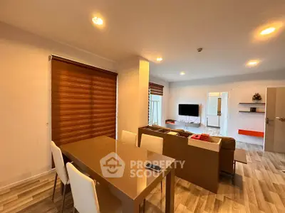Modern living room with stylish dining area and cozy seating, featuring elegant lighting and contemporary decor.