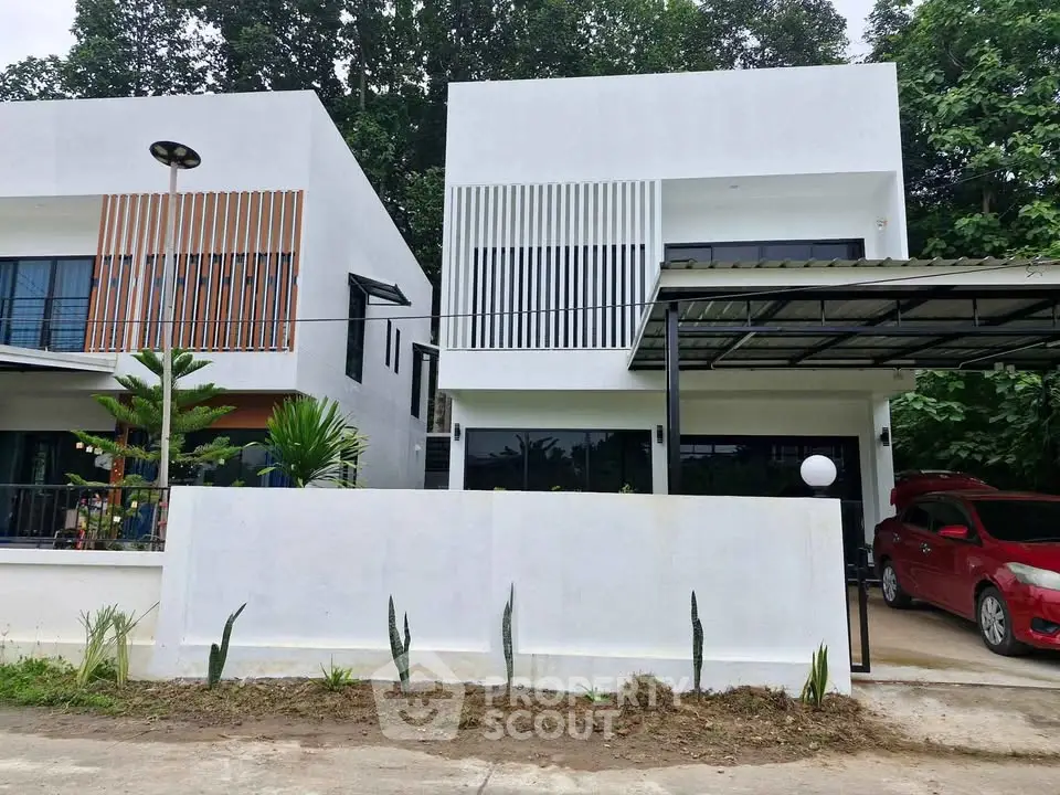 Modern white two-story house with carport and minimalist design