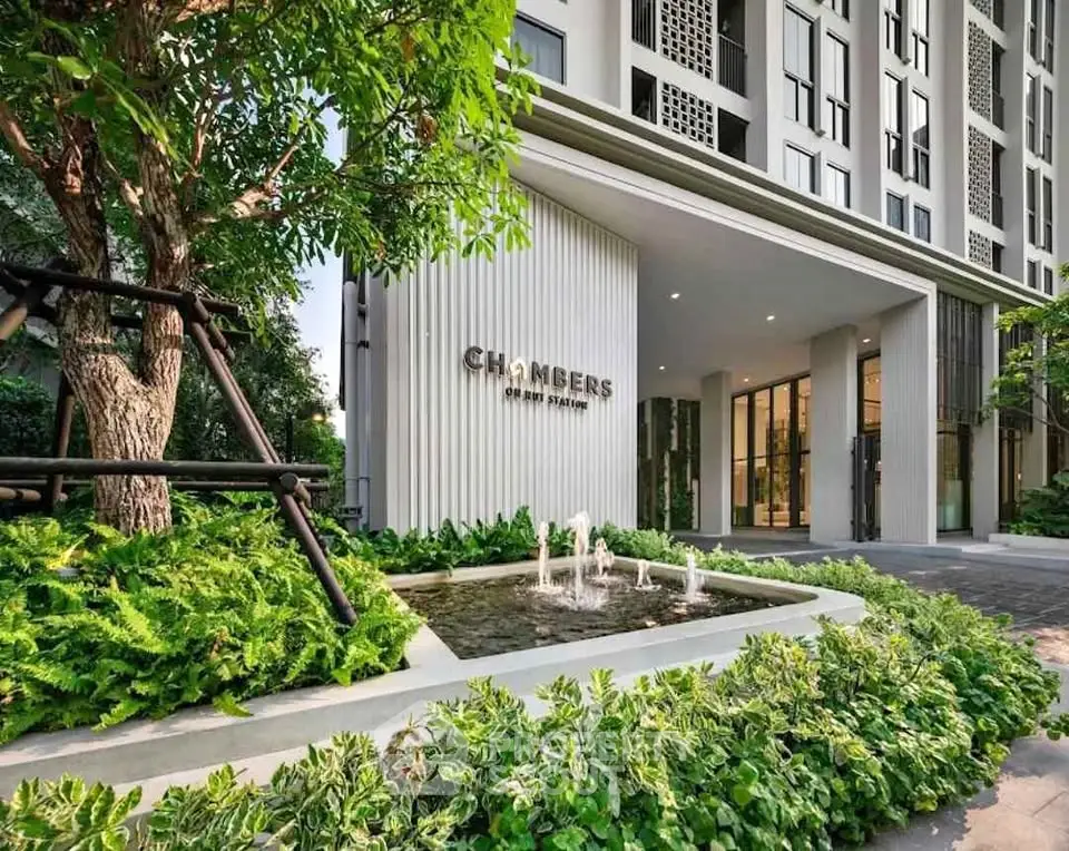 Modern building entrance with lush greenery and water feature