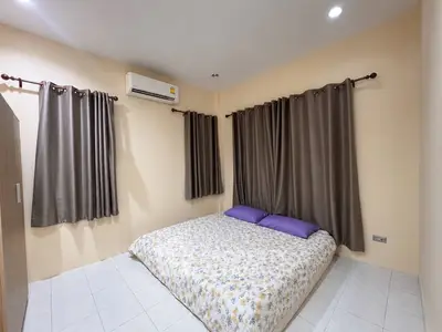 Cozy bedroom with air conditioning and floral bedding, perfect for relaxation.