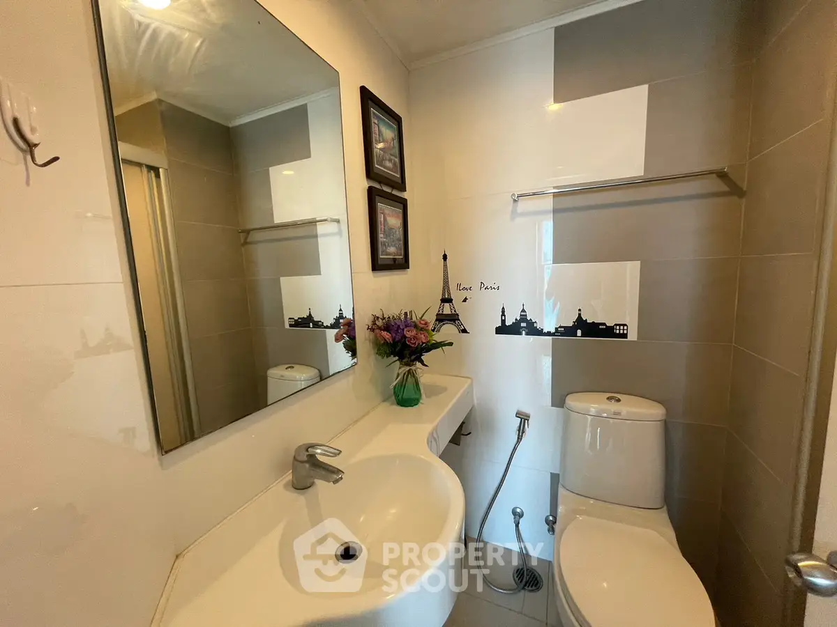 Chic modern bathroom with elegant fixtures and Paris-themed wall art, perfect for urban living.