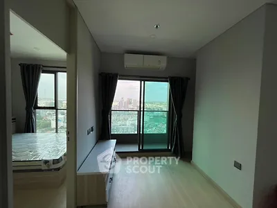 Modern bedroom with city view and large windows in high-rise apartment