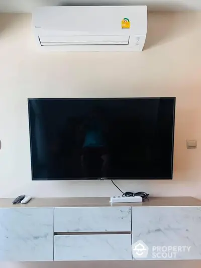 Modern living room with wall-mounted TV and air conditioning unit