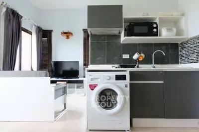 Modern open-plan kitchen with washing machine and sleek appliances