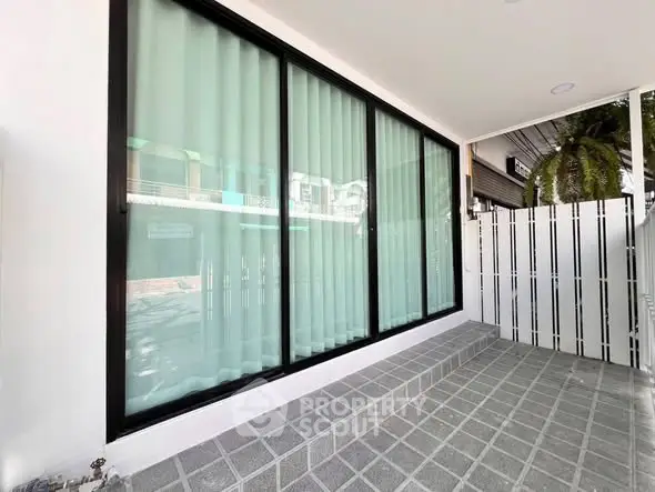 Modern exterior with large glass windows and sleek tiled entrance