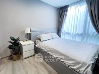 Cozy bedroom with modern decor and large window for natural light