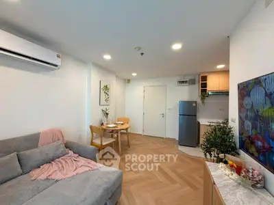 Modern living room with cozy sofa, dining area, and compact kitchen in open layout apartment.