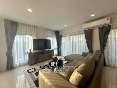 Spacious living room with modern decor, large windows, and comfortable seating in a bright, airy setting.