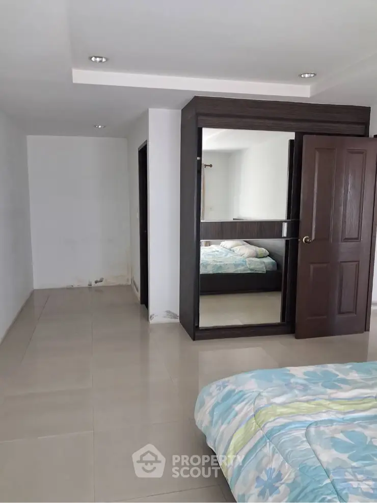 Spacious bedroom with modern design and large mirror wardrobe
