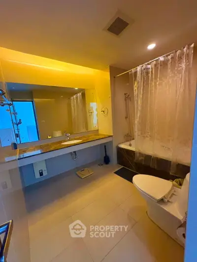 Modern bathroom with elegant lighting and bathtub in a stylish apartment.