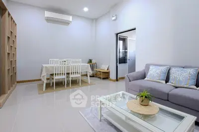 Modern living room with elegant dining area and cozy sofa, perfect for family gatherings.