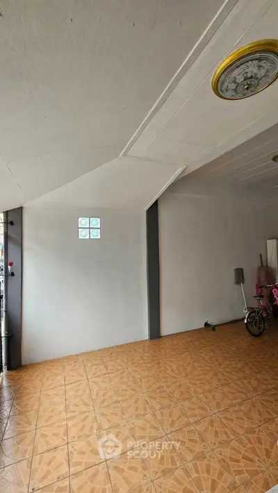 Spacious tiled room with bicycle and mop, ideal for versatile use.