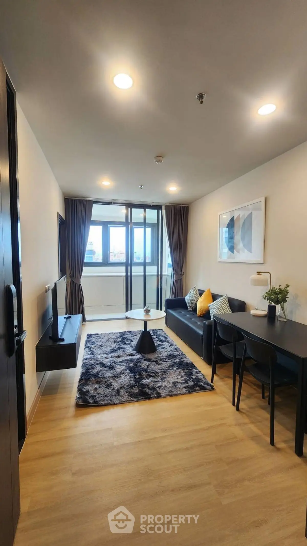 Modern living room with stylish decor and large windows offering natural light.