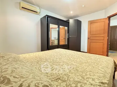 Cozy bedroom with elegant wardrobe and air conditioning in modern apartment.