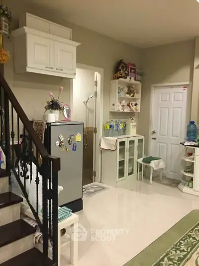 Charming kitchen area with modern fridge and ample storage in cozy home interior.