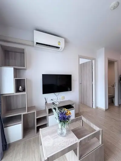 Modern living room with stylish wooden furniture and wall-mounted TV, featuring air conditioning and elegant decor.