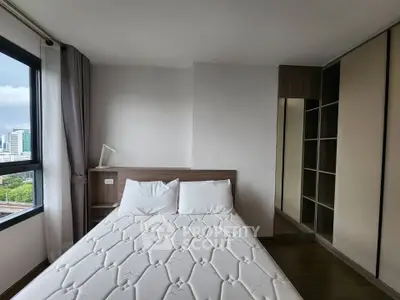 Modern bedroom with city view, featuring a comfortable bed and sleek wardrobe.