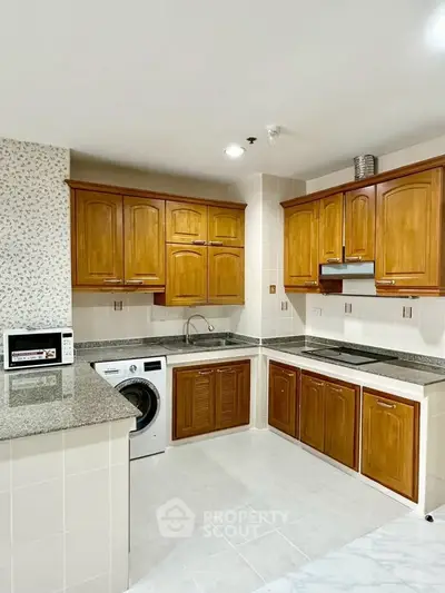 Spacious kitchen with wooden cabinets and modern appliances in a stylish home.