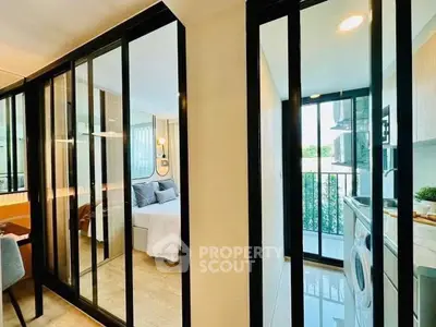 Modern apartment interior with glass partitions and cozy bedroom view.