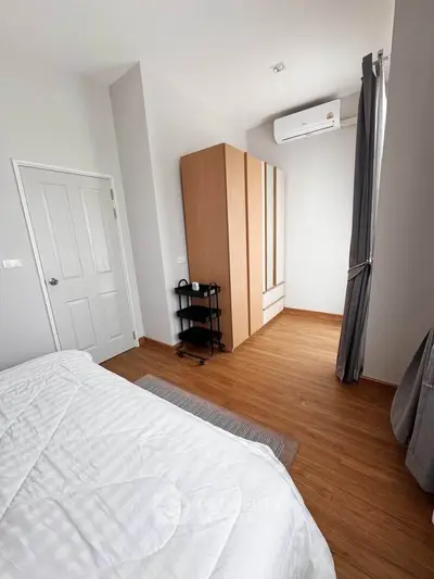 Modern bedroom with wooden flooring and sleek wardrobe design