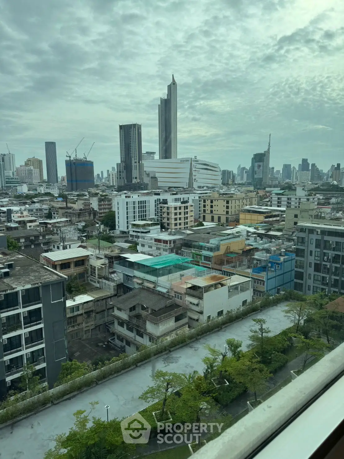 Stunning cityscape view from high-rise building with lush greenery and skyline