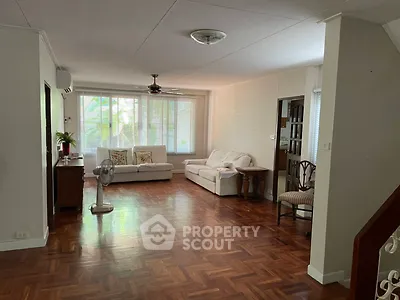 Spacious living room with elegant wooden flooring and cozy seating area.