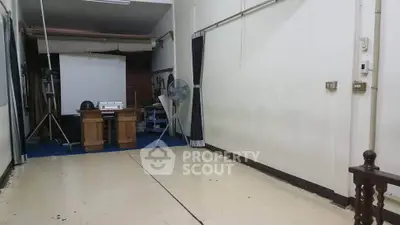 Spacious room with minimal furnishings and a fan, ideal for creative studio or workshop setup.