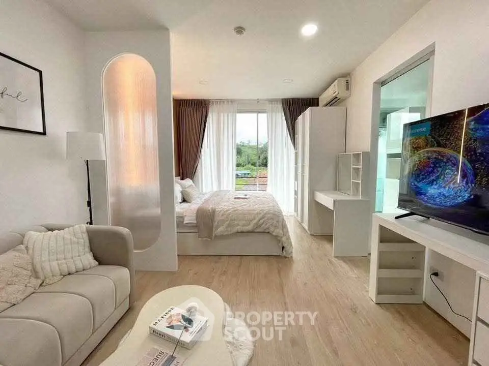 Modern open-plan living room and bedroom with stylish decor and natural light.